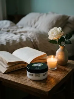 Crema N°5 en la mesita de noche con libro y vela
